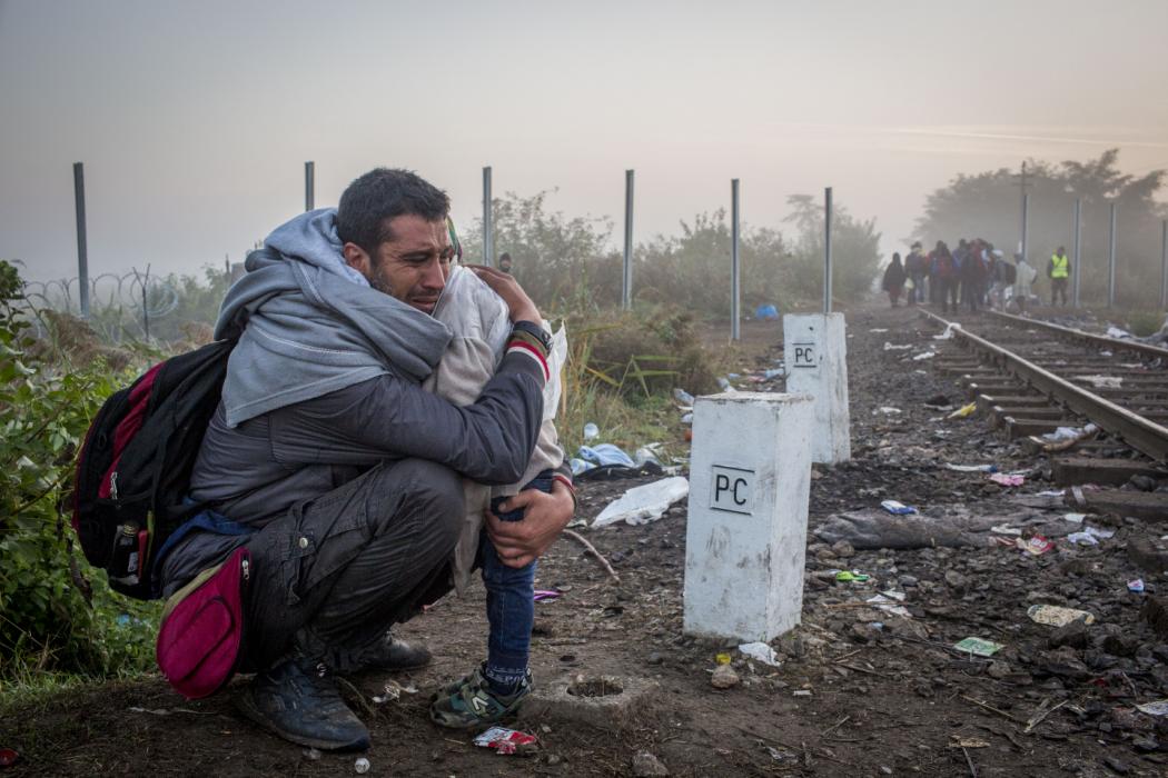A father break down when reacihng the Hungarian border, after walking his way with his family from Serbia. Hungary, Francesca Volpi, 13th September 2015.