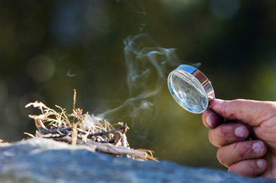 Lighting a fire with a magnifying glass